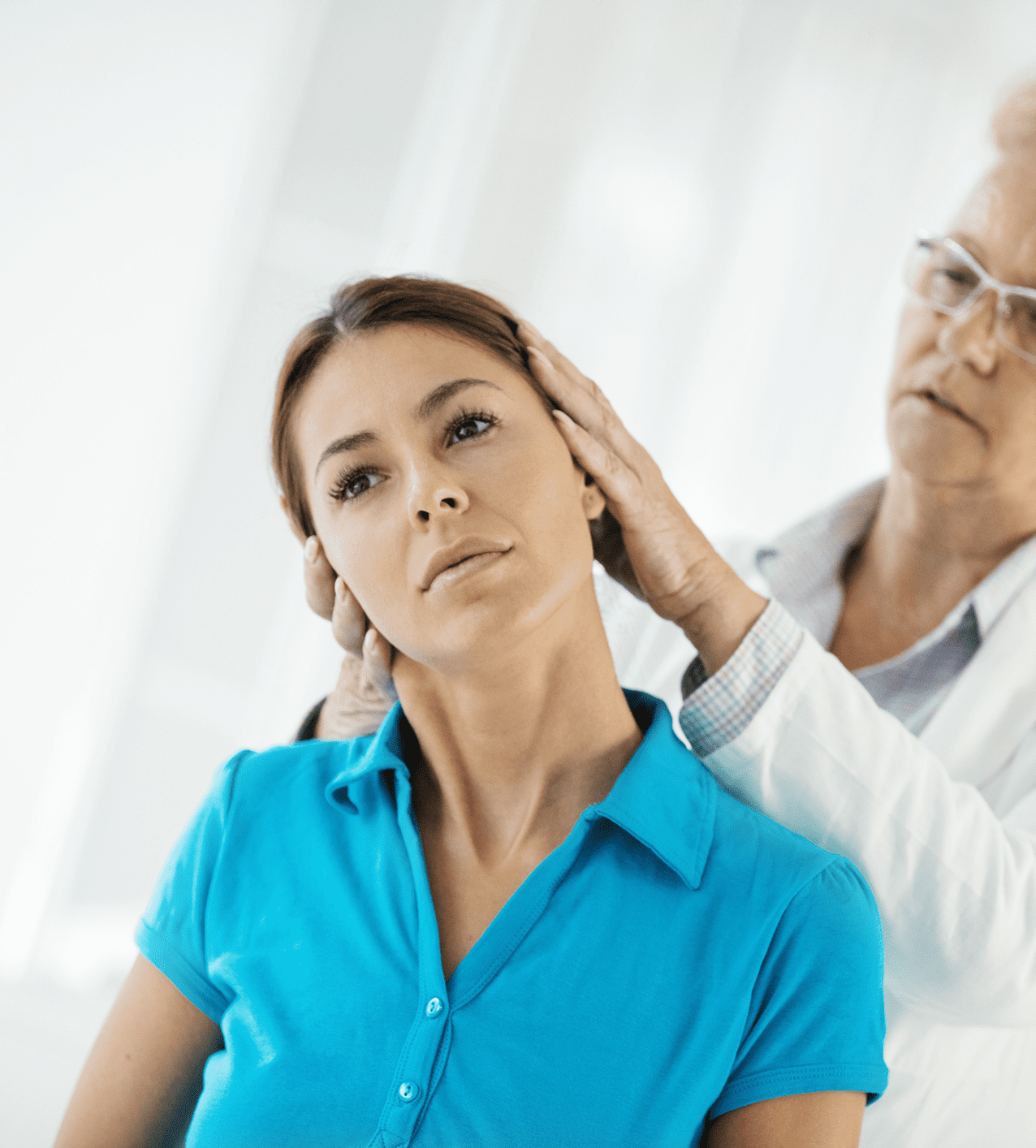 A doctor examining a woman's neck during a medical check-up.
