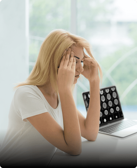 Woman with headache near laptop.