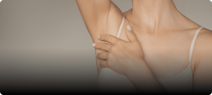 Woman touching her underarm in tank top.