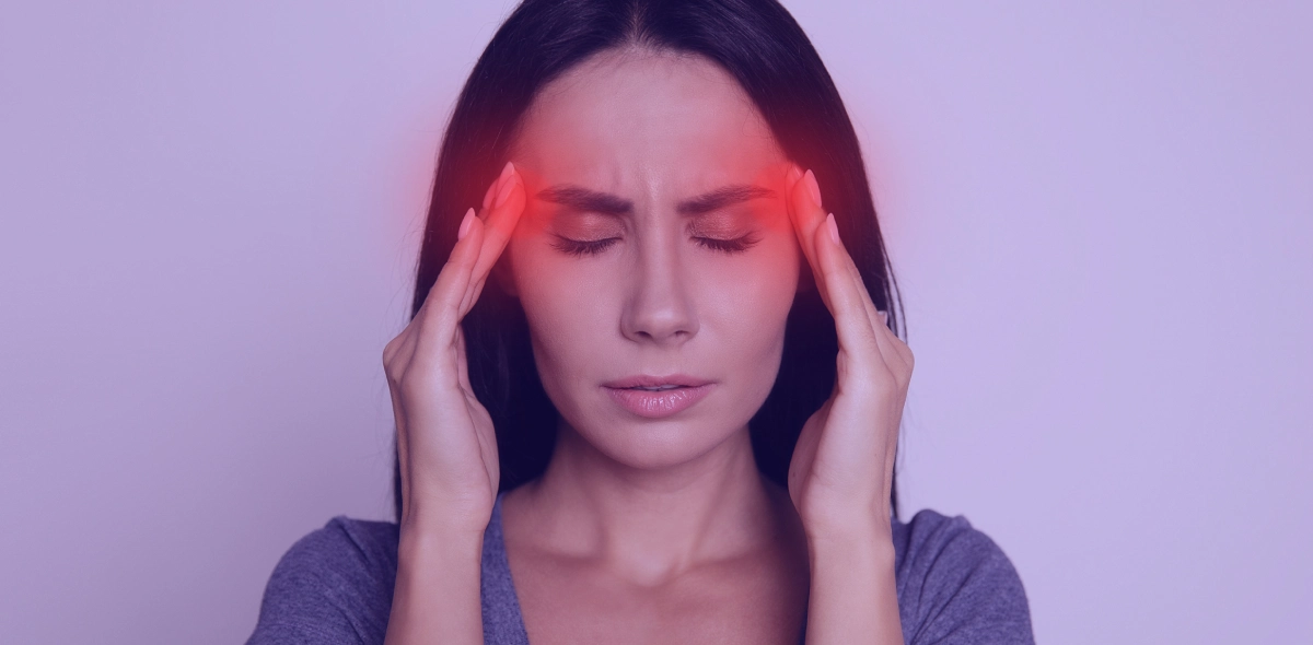 Woman with headache holding her temples.