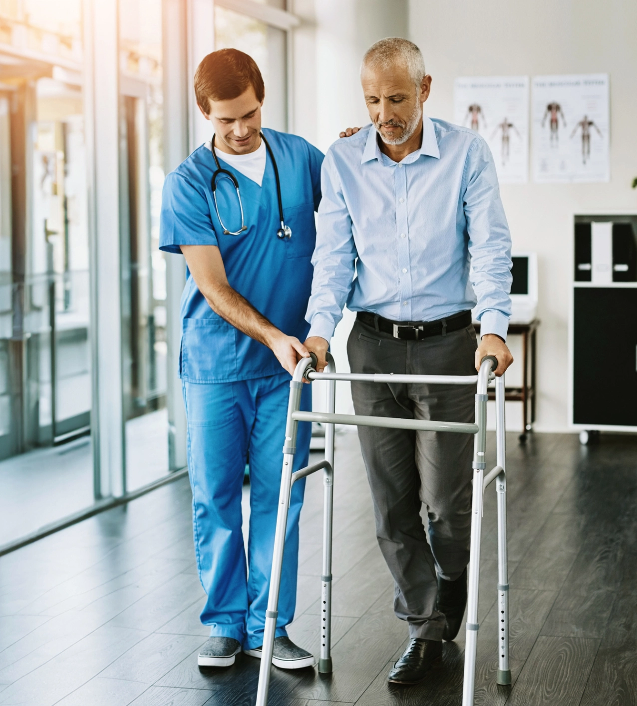 Healthcare professional assisting man with walker.