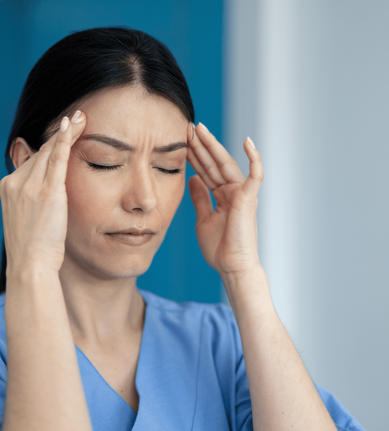 Woman experiencing a headache, pressing temples with eyes closed.