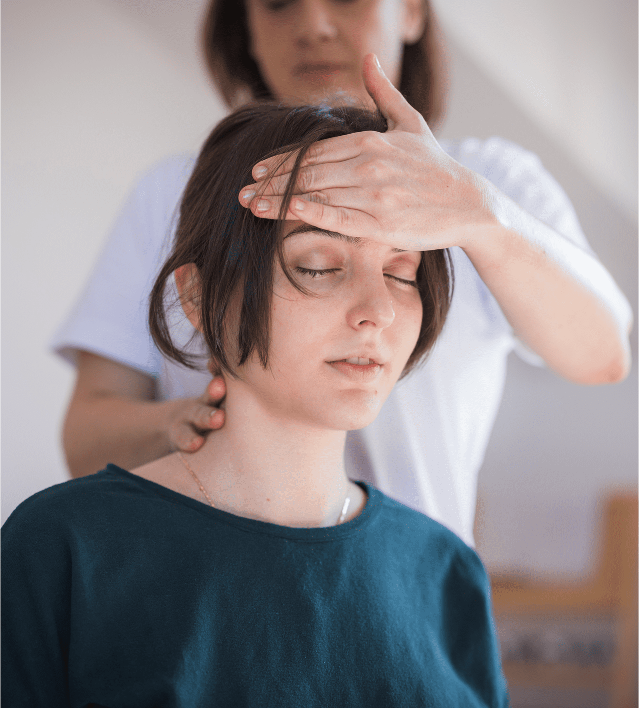 A person receiving a head massage from another individual.
